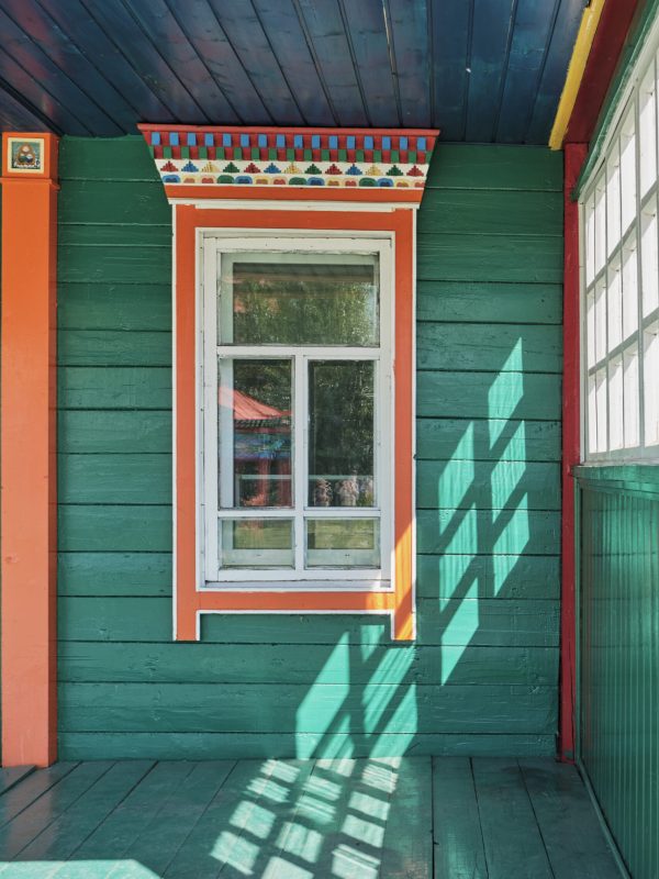 Wooden veranda with windows and painted walls. Choira dugan, buddhist temple in Ivolginsky Datsan, Republic of Buryatia, Russia . Traditional symbolic details of colorful decor. Architecture concept